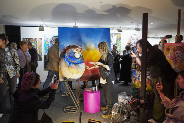 アートショッピングパリ2023（春会期）の会場内で、絵を描くパフォーマンスをしているアーティスト