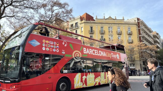 バルセロナの街中で赤く2階建ての観光バスが走っている様子